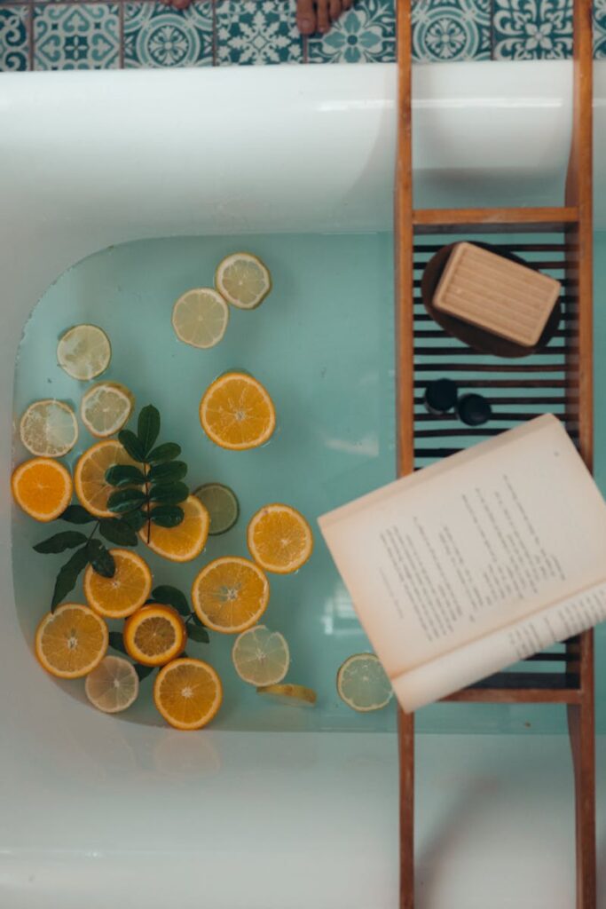 A serene bath setup with citrus fruits, a book, and a bar of soap for ultimate relaxation.